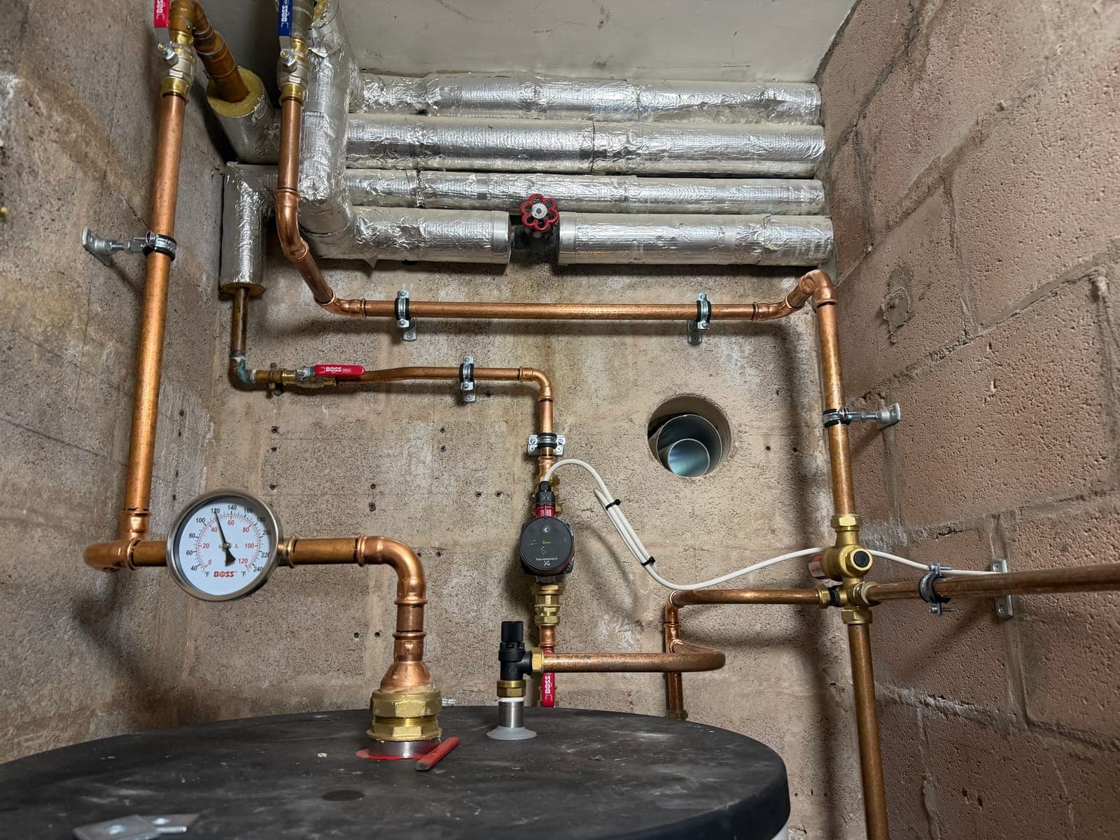 Heating pipework and pressure gauge in the plant room